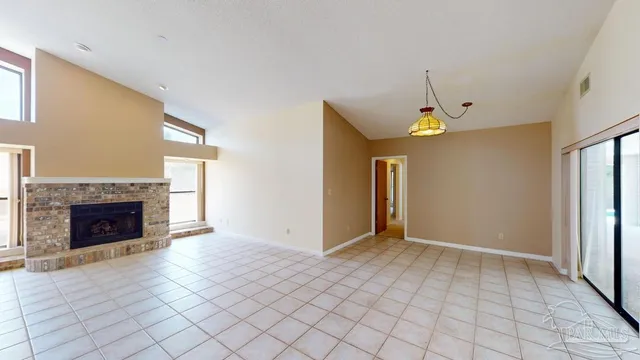a view of an empty room with window and fire place