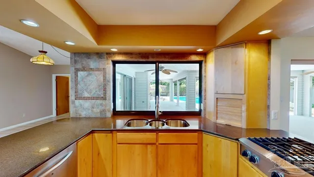 a kitchen with a sink and large windows