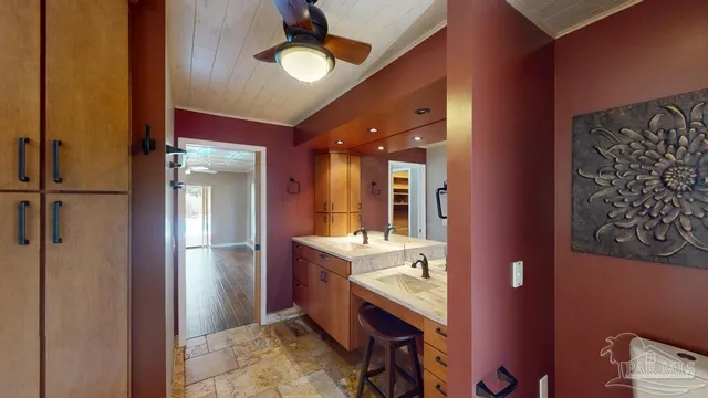 a room with chandelier fan and a dining table