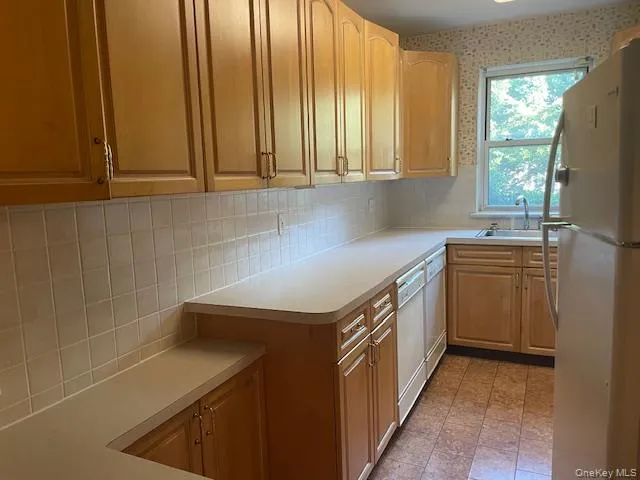 a utility room with stainless steel appliances a sink and cabinets