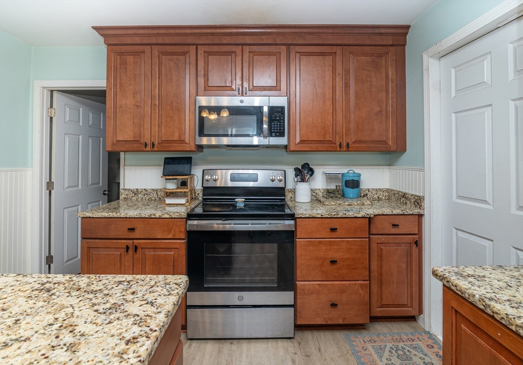 220 West Main Street Dudley, MA 01571 - Photo 14 of 42 a kitchen with granite countertop wooden cabinets and stainless steel appliances