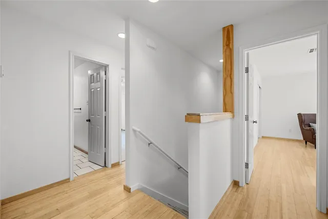 a view of a hallway with wooden floor and staircase