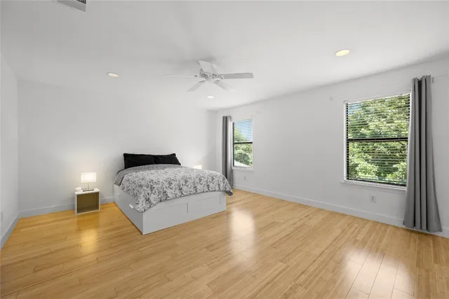 a bedroom with a bed and wooden floor