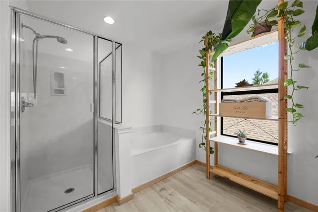 a bathroom with a glass shower door and a window