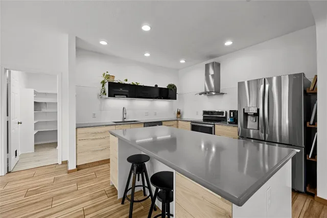 a kitchen with kitchen island a refrigerator stove microwave and cabinets