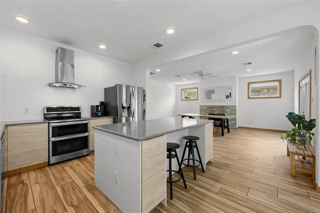 a kitchen with stainless steel appliances a refrigerator and a stove top oven
