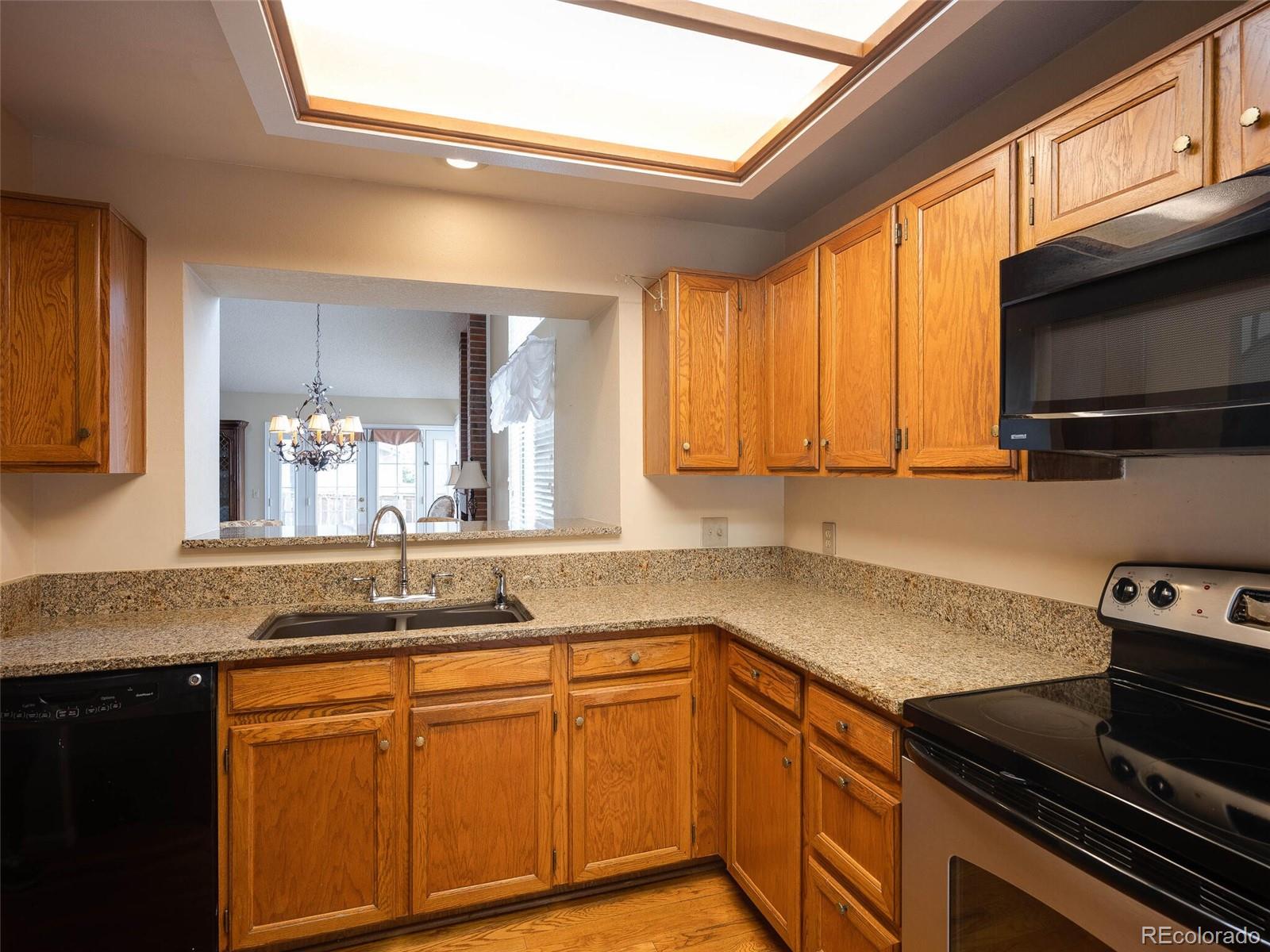 8634 Redstone Street Highlands Ranch, CO 80126 - Photo 3 of 25 a kitchen with granite countertop stainless steel appliances a sink stove and cabinets