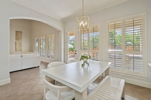 a kitchen with stainless steel appliances granite countertop a stove top oven a sink a dining table and chairs