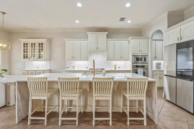 a large kitchen with stainless steel appliances granite countertop a stove and a sink