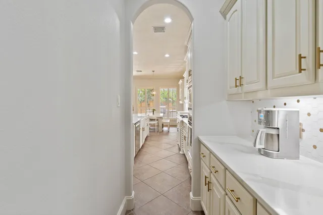 a spacious bedroom with a bed and chandelier