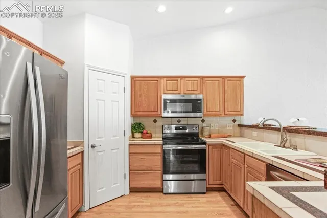 a kitchen with stainless steel appliances a refrigerator stove and sink
