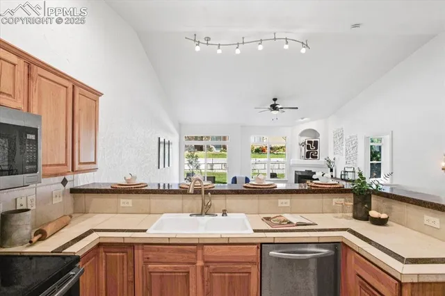 a kitchen with kitchen island granite countertop a sink cabinets and stainless steel appliances