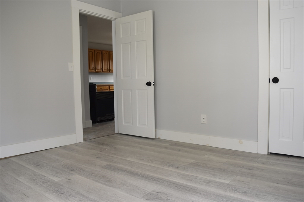 7 Pearl Street Southbridge, MA 01550 - Photo 27 of 41 an empty room with wooden floor and entrance door