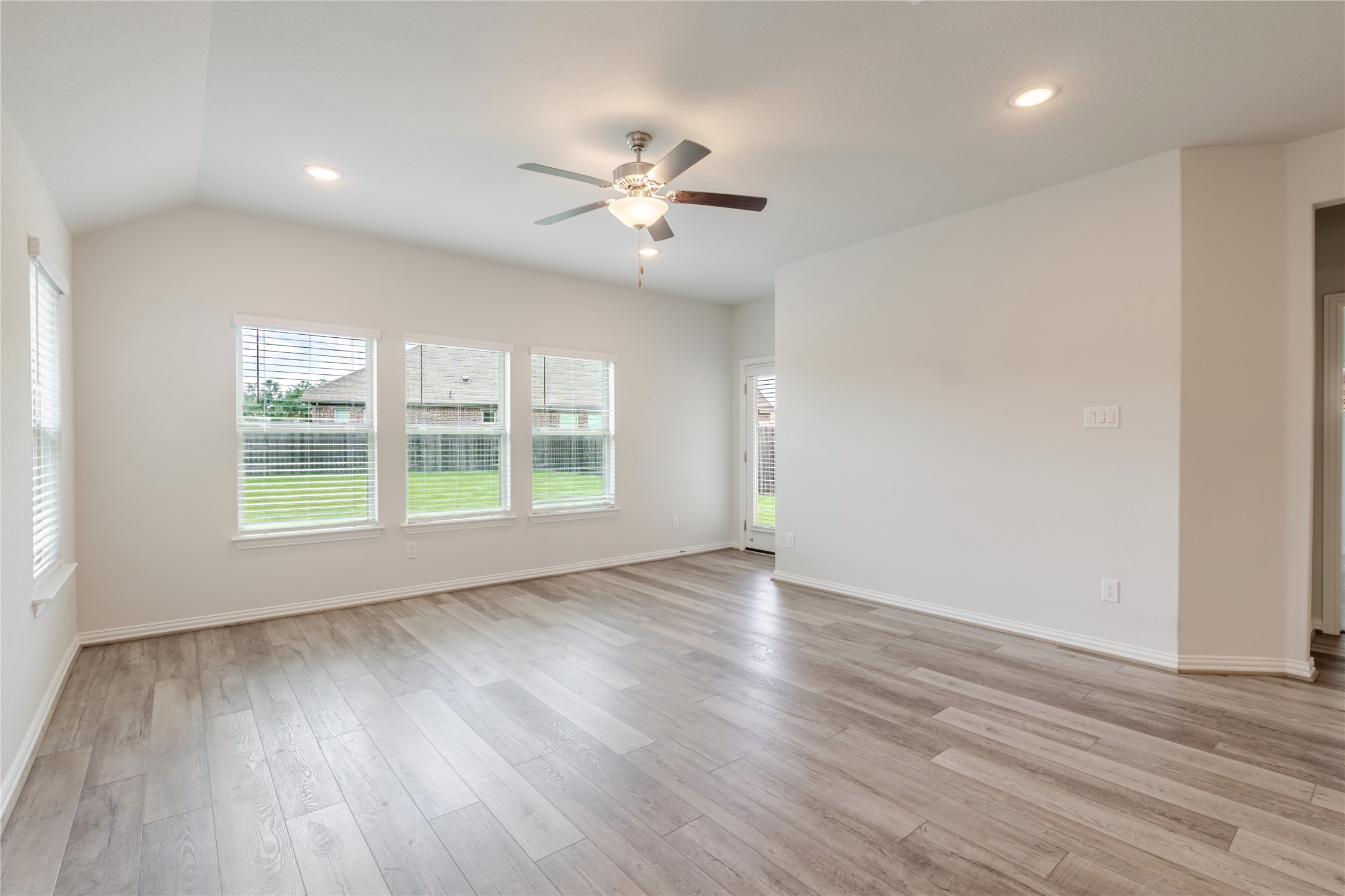 1117 Terrace View Georgetown, TX 78628 - Photo 11 of 25 Open-concept living space featuring wood-finish flooring, a vaulted ceiling, recessed lighting, and a ceiling fan with integrated light