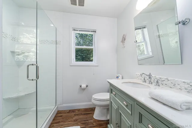 a bathroom with a granite countertop sink toilet and shower