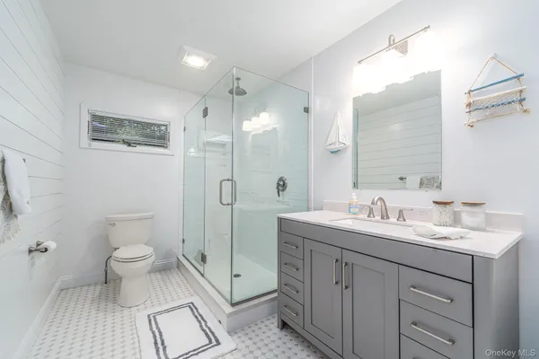 a bathroom with a double vanity sink toilet and shower
