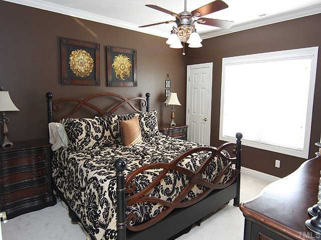4824 Morning Edge Drive Raleigh, NC 27613 - Photo 4 of 12 a bedroom with a bed and a chandelier