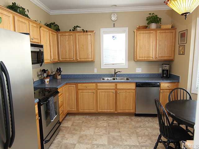 4824 Morning Edge Drive Raleigh, NC 27613 - Photo 5 of 12 a kitchen with granite countertop a sink stove and refrigerator