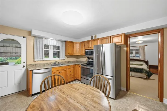 a kitchen with stainless steel appliances granite countertop a refrigerator a stove and a sink with cabinets
