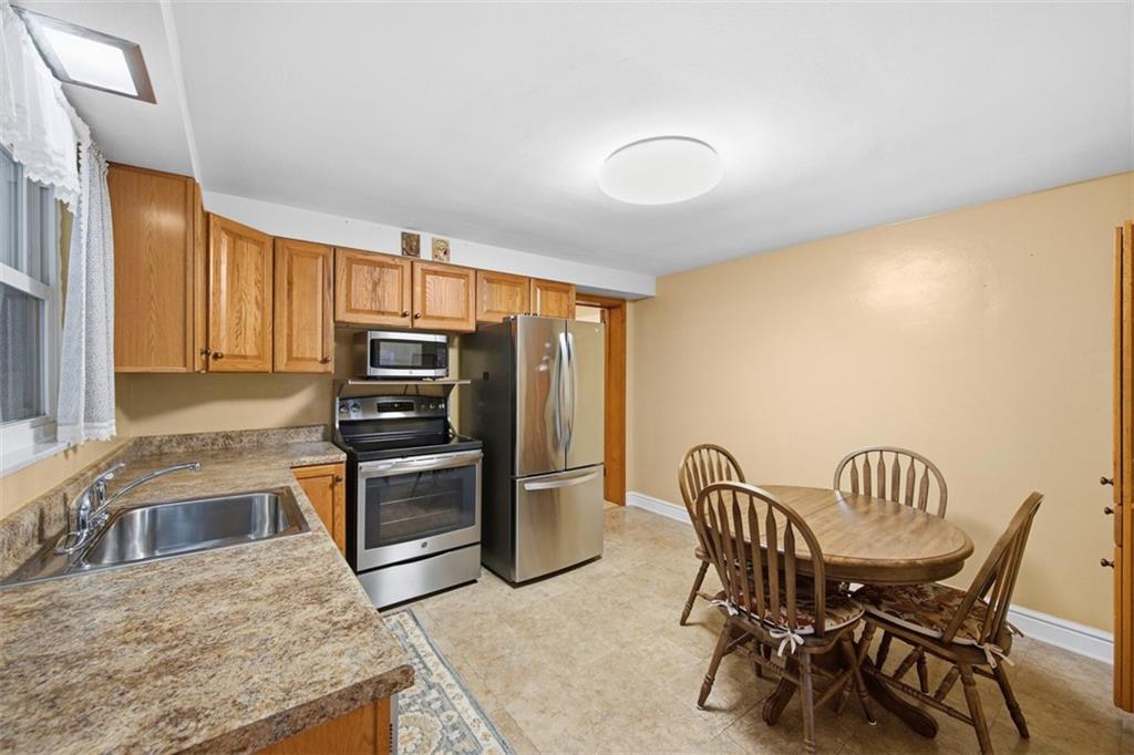 108 Starling Drive McKees Rocks, PA 15136 - Photo 7 of 37 a kitchen with stainless steel appliances granite countertop a stove top oven a sink a dining table and chairs