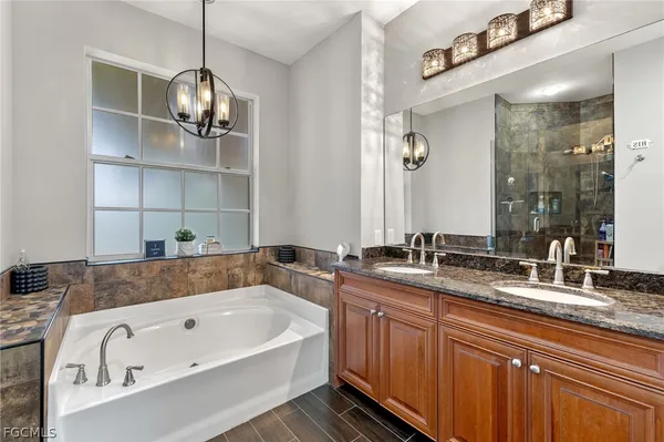 a bathroom with a tub sink and mirror