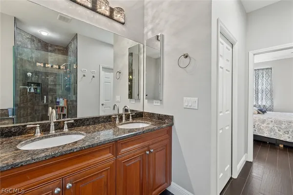 a en suite bathroom with a granite countertop sink and a mirror