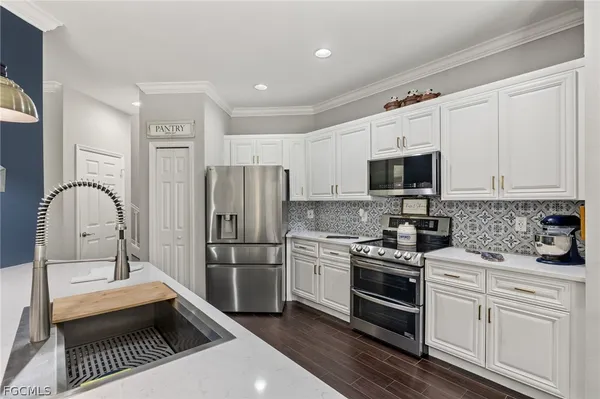 a kitchen with white cabinets and stainless steel appliances