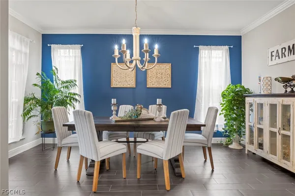 a dining room with furniture potted plants and wooden floor