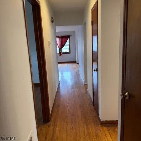 a view of hallway with wooden floor