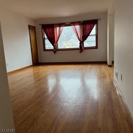 an empty room with wooden floor and a window