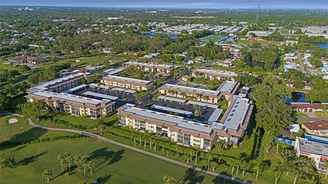 an aerial view of a city with lots of residential buildings ocean and mountain view in back