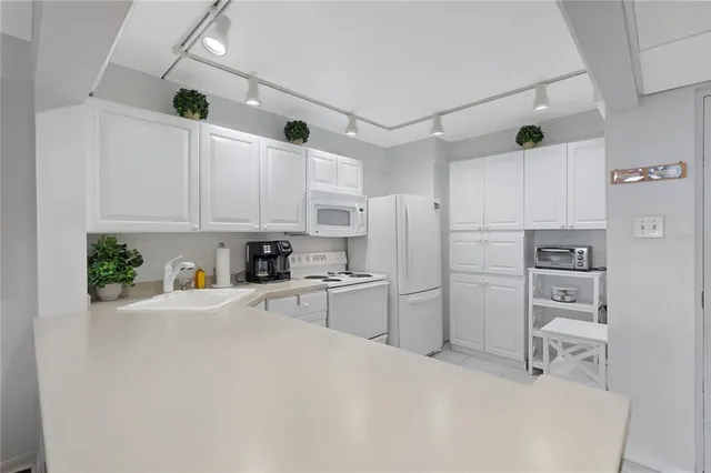 a kitchen with stainless steel appliances a refrigerator sink and white cabinets