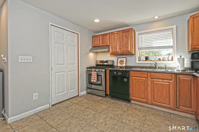 a kitchen with stainless steel appliances granite countertop a stove a sink and a refrigerator