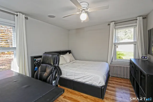 a bedroom with a bed and wooden floor