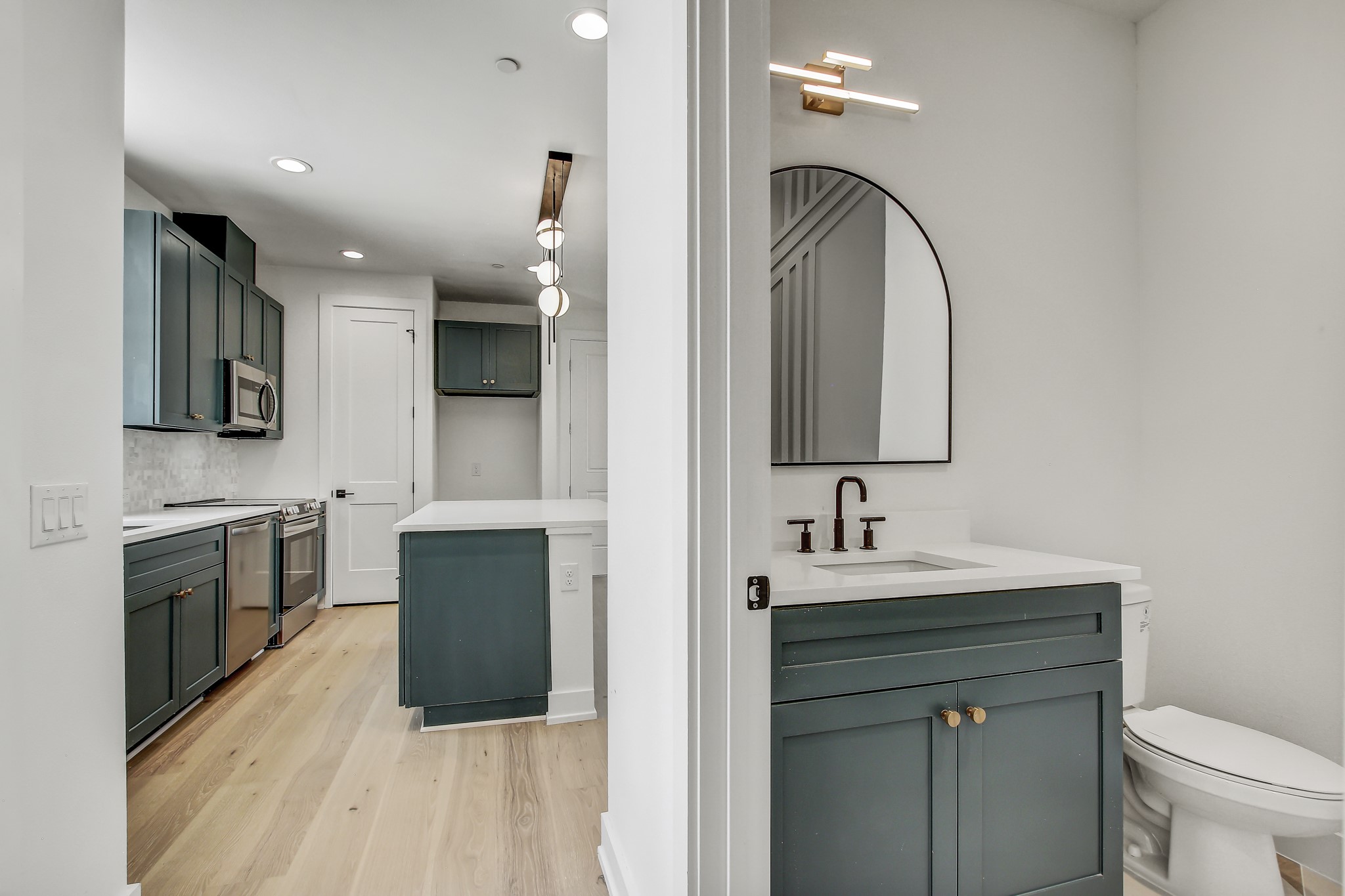 4127 East 12th Street, Unit 5 Austin, TX 78721 - Photo 16 of 33 Full bath featuring two vanities, wood finished floors, recessed lighting, toilet, and tasteful backsplash