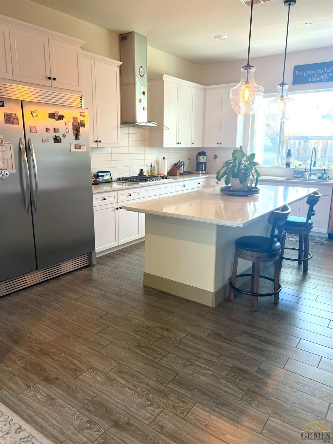 Undisclosed Address Shafter, CA 93263 - Photo 3 of 11 a kitchen with stainless steel appliances granite countertop a refrigerator a sink dishwasher a stove and white cabinets with wooden floor