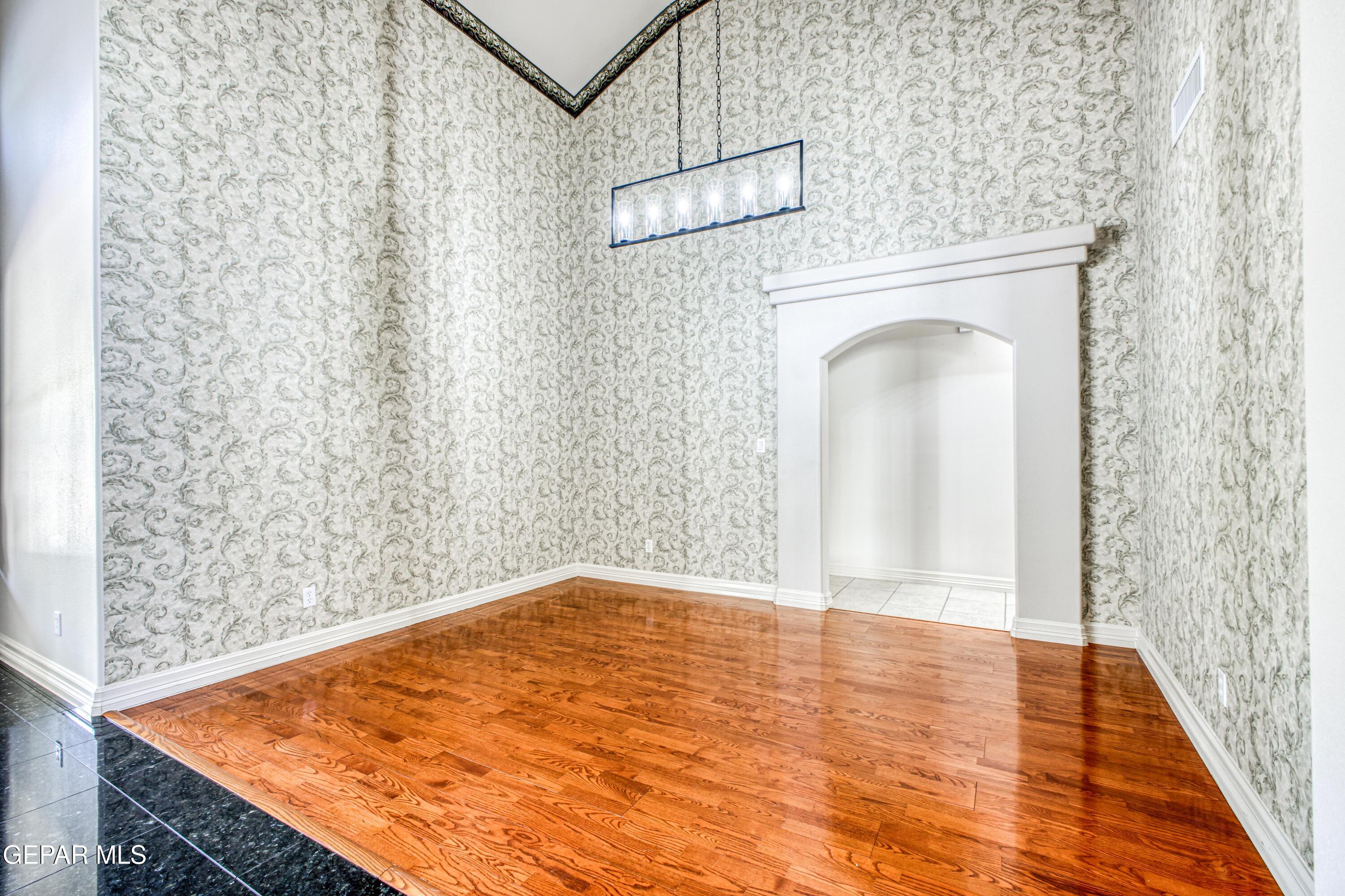 6565 Eagle Ridge Drive El Paso, TX 79912 - Photo 13 of 60 a view of a hallway with wooden floor and a chandelier