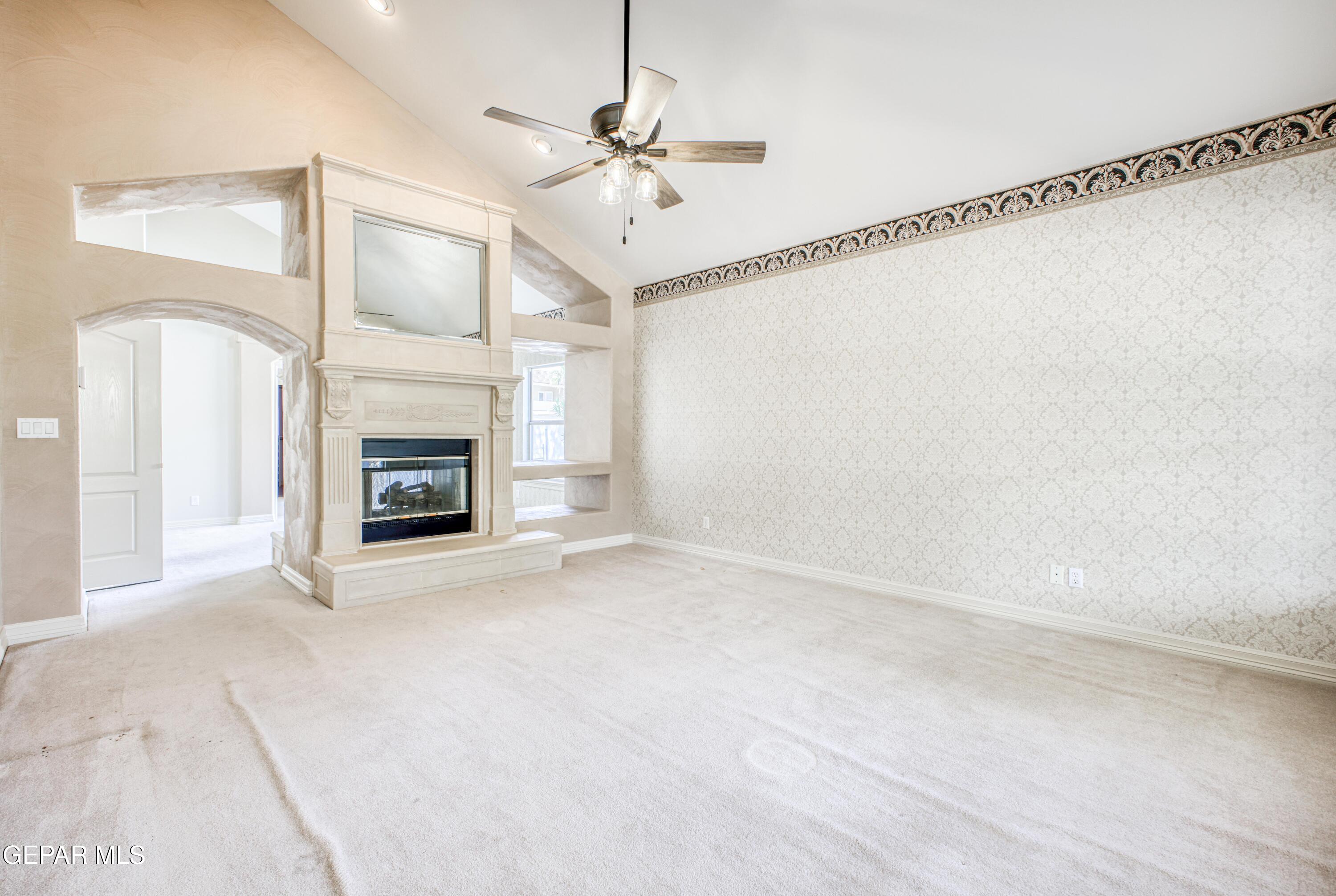 6565 Eagle Ridge Drive El Paso, TX 79912 - Photo 37 of 60 a view of an empty room with a fireplace and a fan