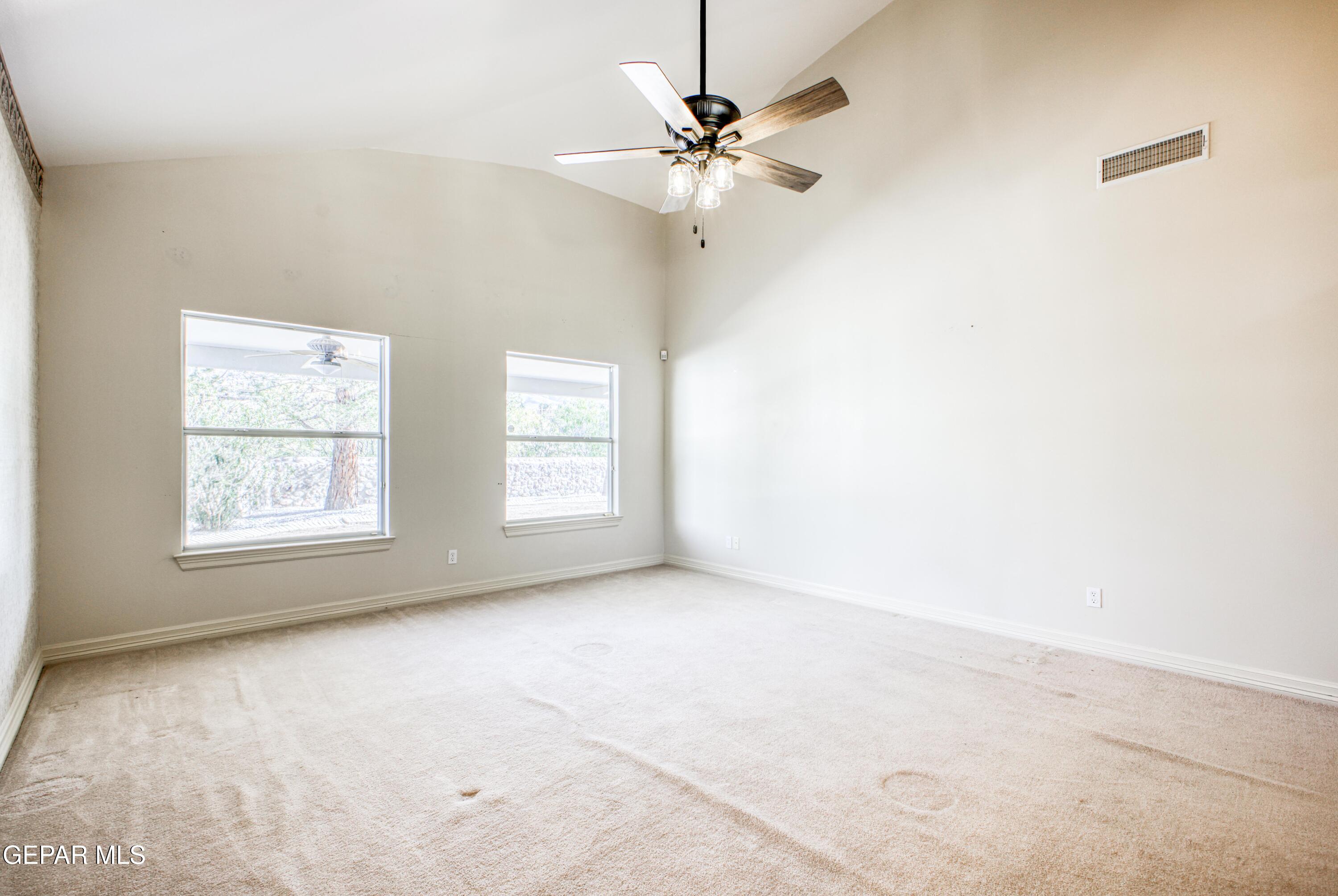 6565 Eagle Ridge Drive El Paso, TX 79912 - Photo 38 of 60 an empty room with windows and fan