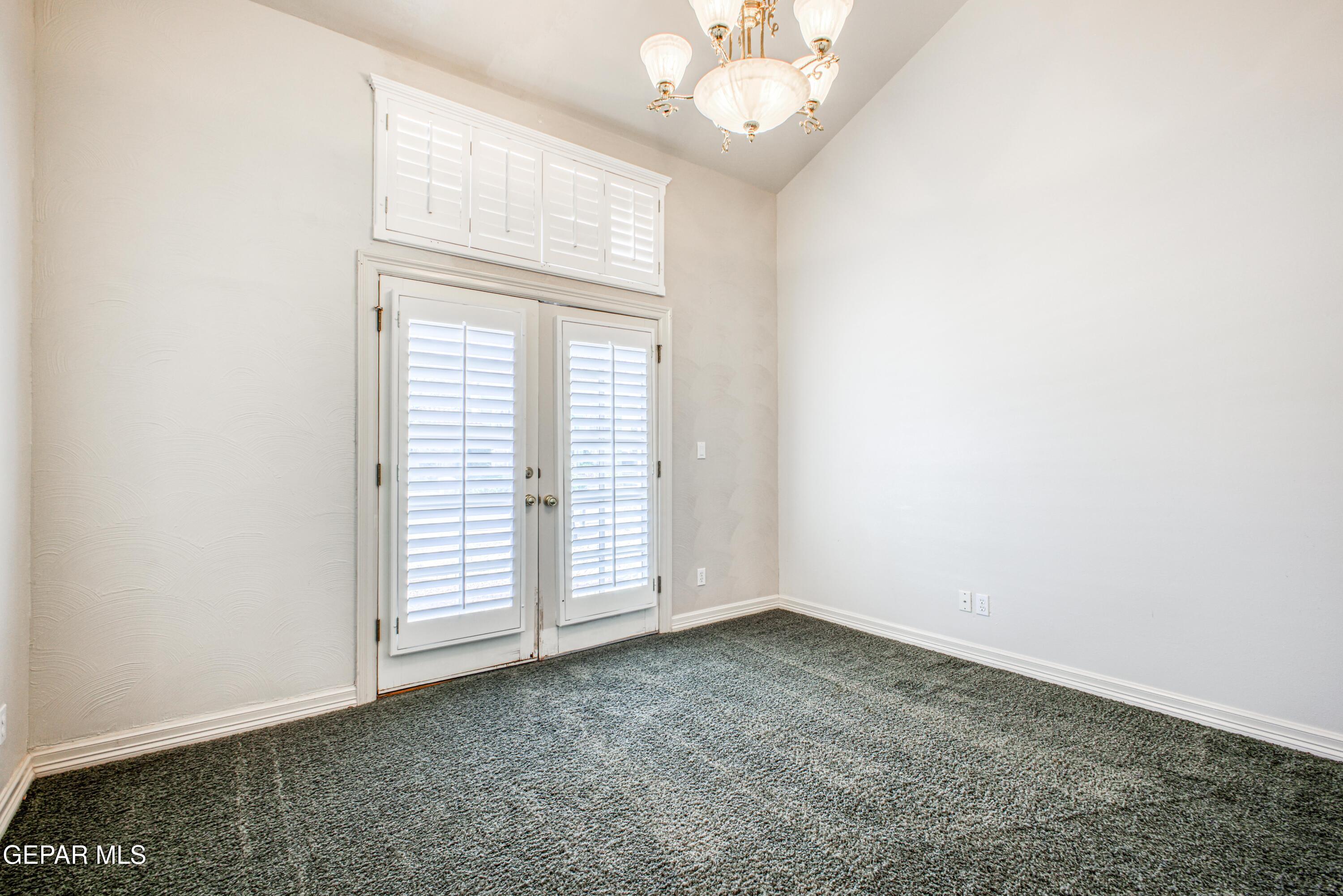 6565 Eagle Ridge Drive El Paso, TX 79912 - Photo 42 of 60 an empty room with a chandelier fan and windows
