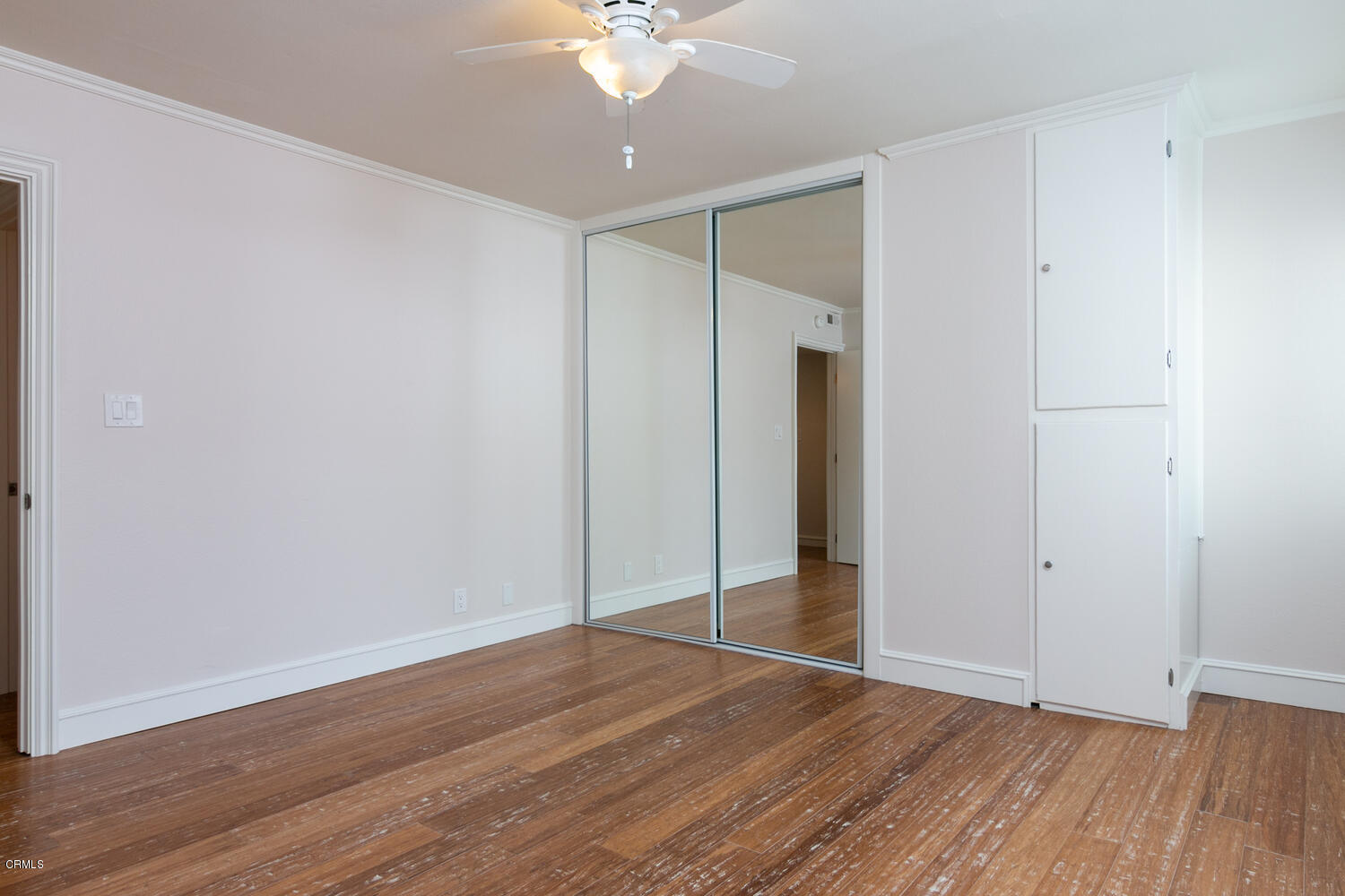 5120 West Wooley Road, Unit 2 Oxnard, CA 93035 - Photo 18 of 35 an empty room with wooden floor and a ceiling fan