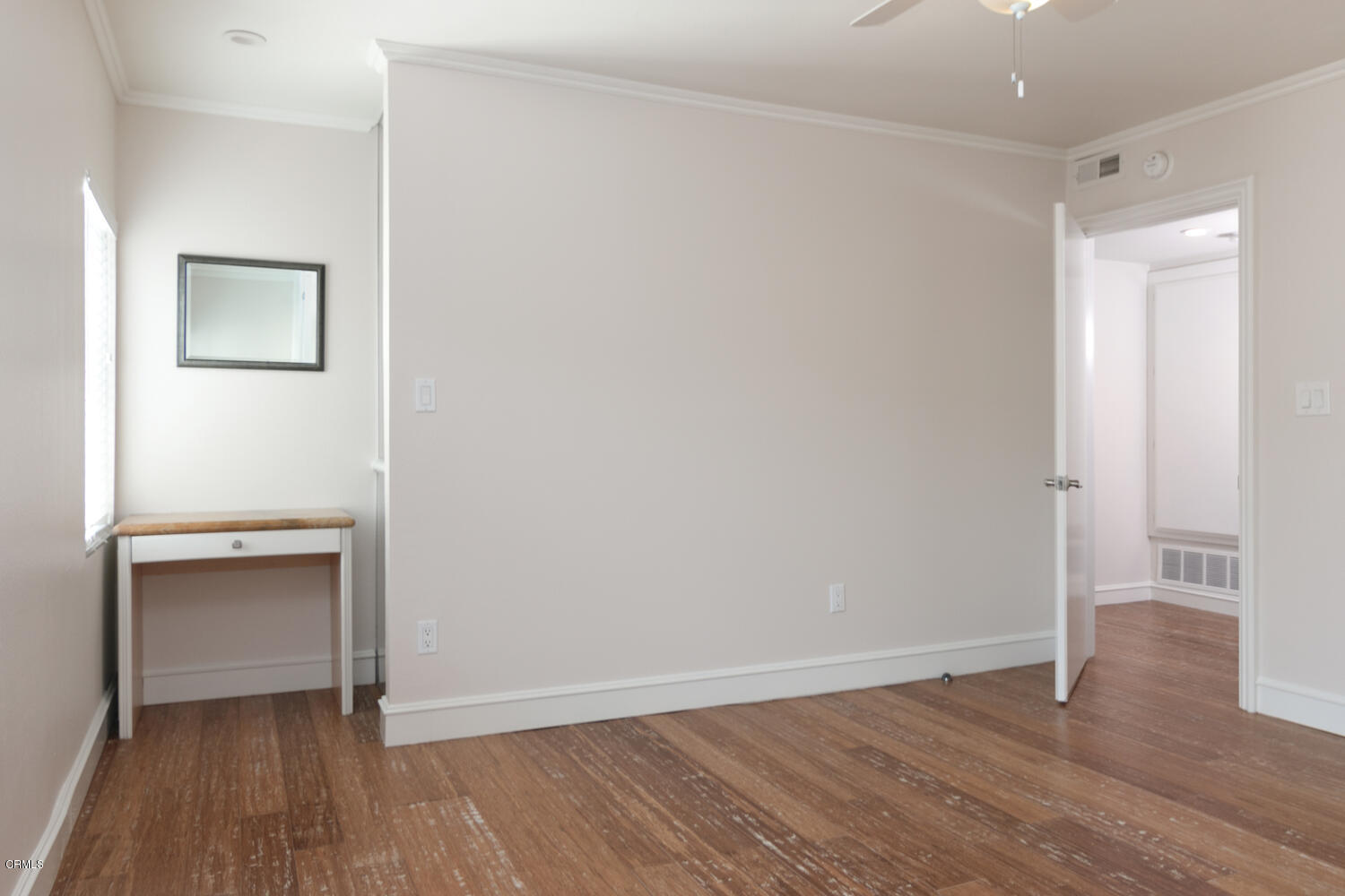 5120 West Wooley Road, Unit 2 Oxnard, CA 93035 - Photo 19 of 35 a view of an empty room and wooden floor and a window