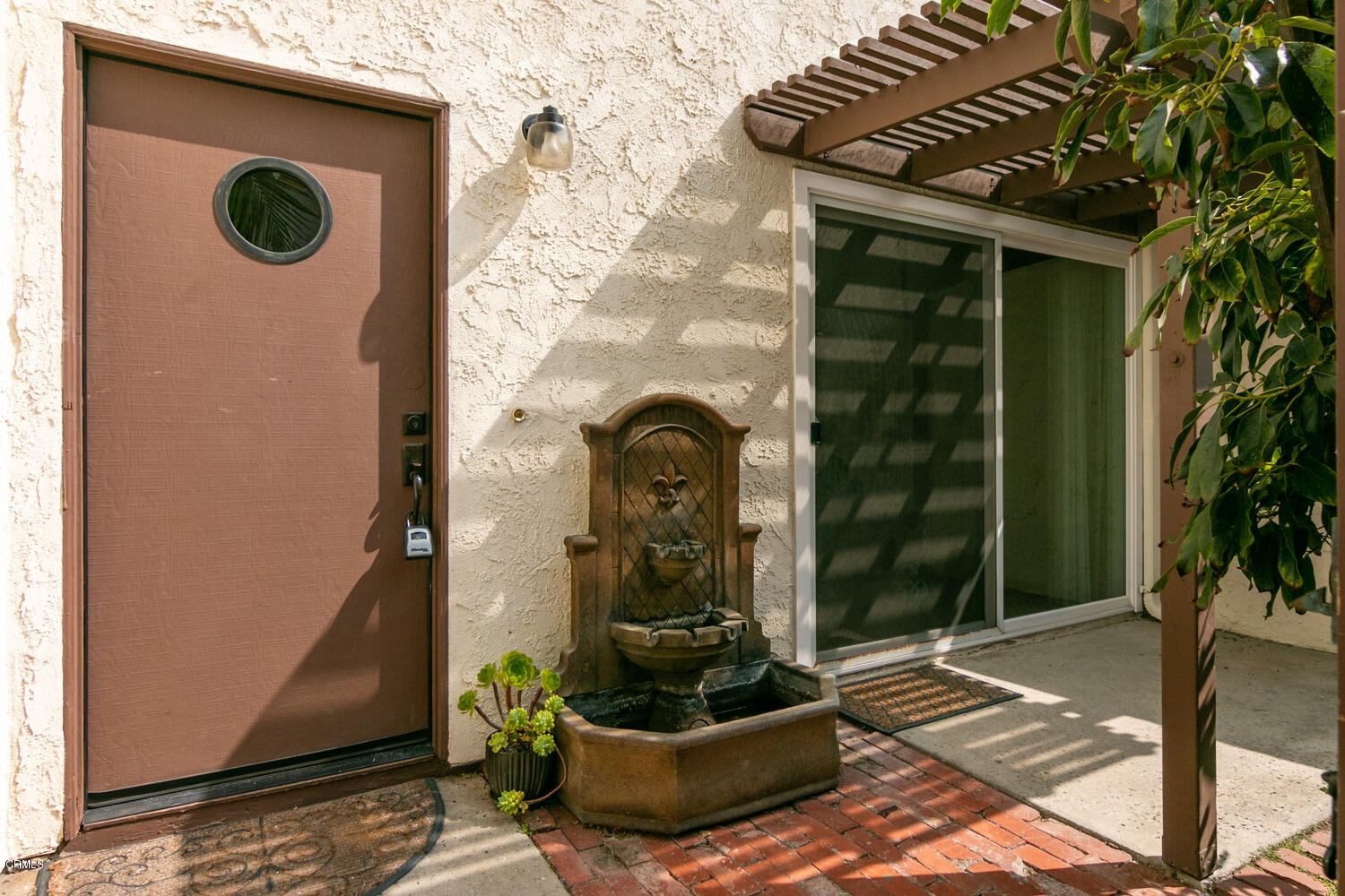 5120 West Wooley Road, Unit 2 Oxnard, CA 93035 - Photo 5 of 35 a view of a door of the house with a potted plant and a window