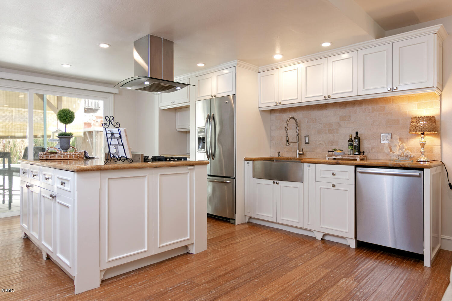 5120 West Wooley Road, Unit 2 Oxnard, CA 93035 - Photo 10 of 35 a kitchen with white cabinets and wooden floor