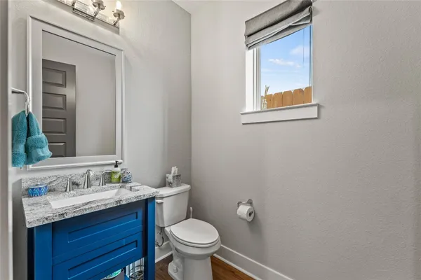 a bathroom with a granite countertop toilet sink and mirror
