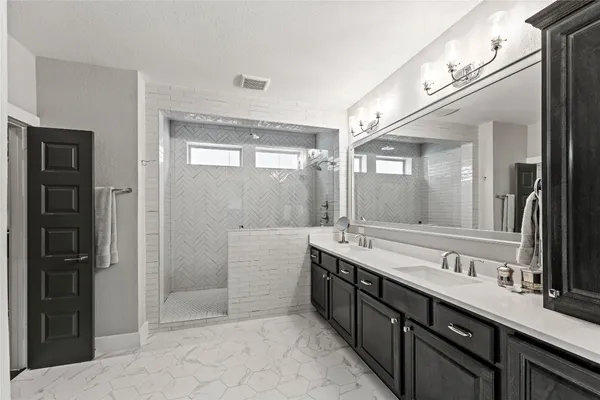 a large bathroom with a double vanity sink a large mirror and a bathtub