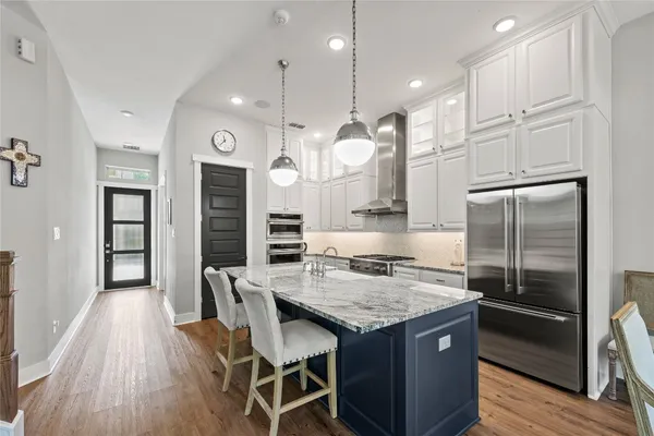 a kitchen with granite countertop a table chairs stainless steel appliances and wooden floor
