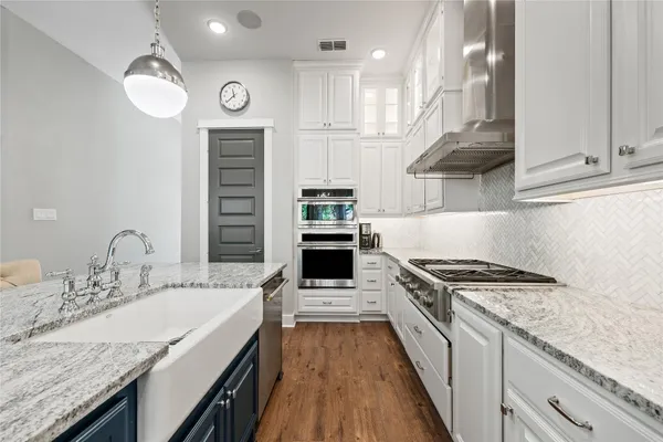a kitchen with stainless steel appliances granite countertop a stove and a sink