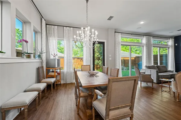 a view of a dining room with furniture large windows and wooden floor
