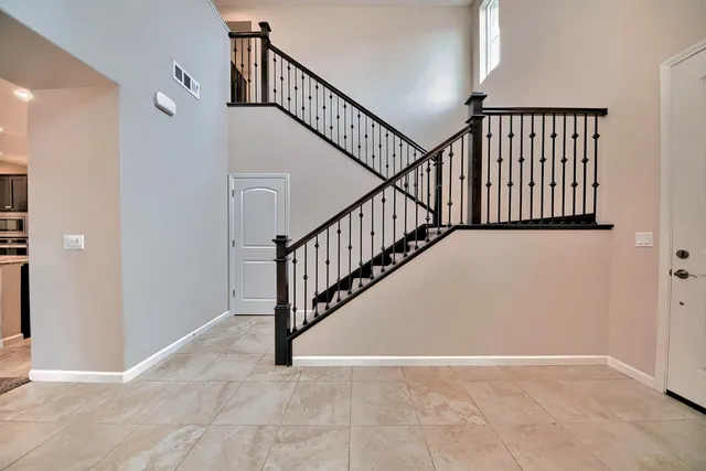 a view of staircase with railing and white walls